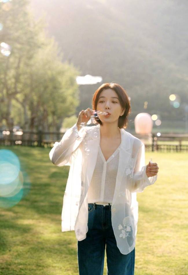王珞丹草坪上吹泡泡好开心 绽放灿烂笑容明媚动人