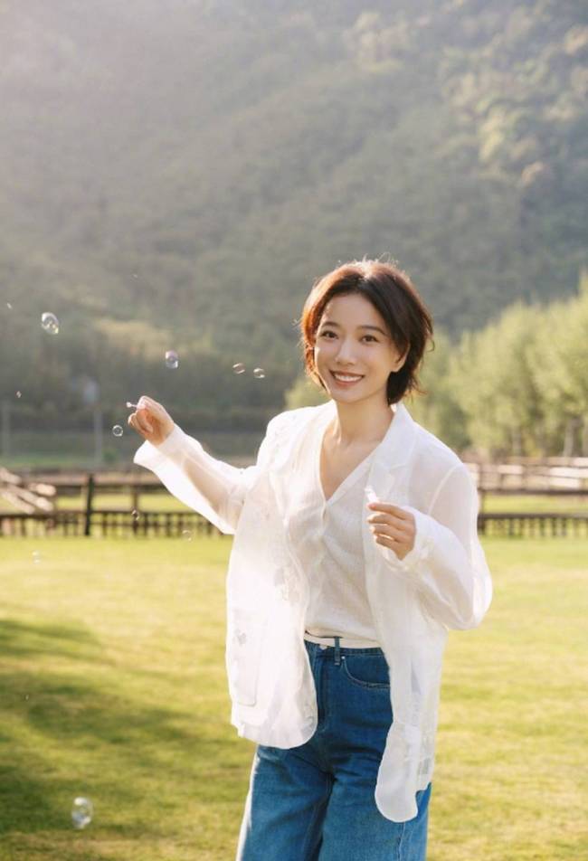 王珞丹草坪上吹泡泡好开心 绽放灿烂笑容明媚动人