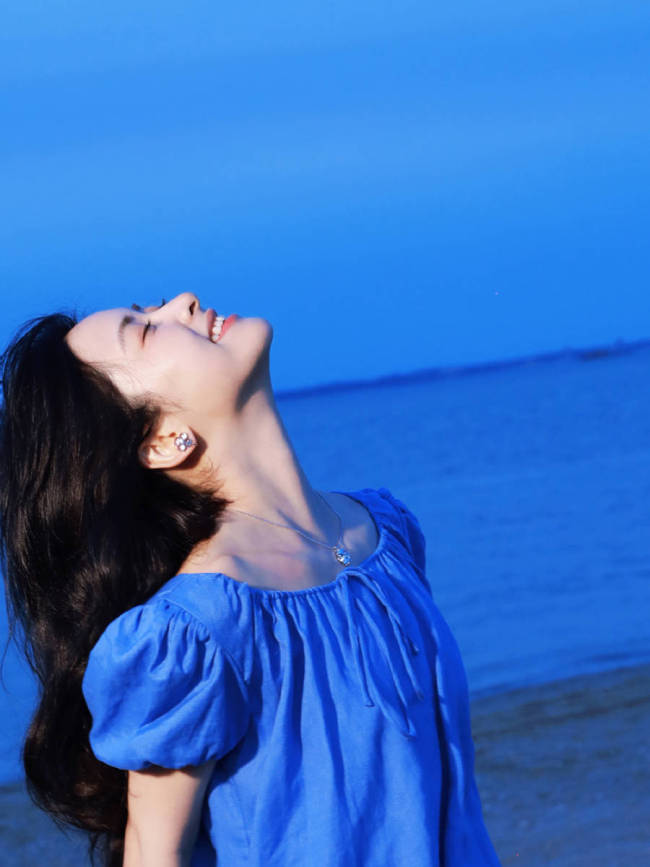 沈月穿蓝色连衣裙海边拍照 笑容甜美氛围感拉满