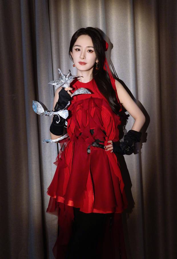 杨幂手拿银色花朵，姿态优雅。