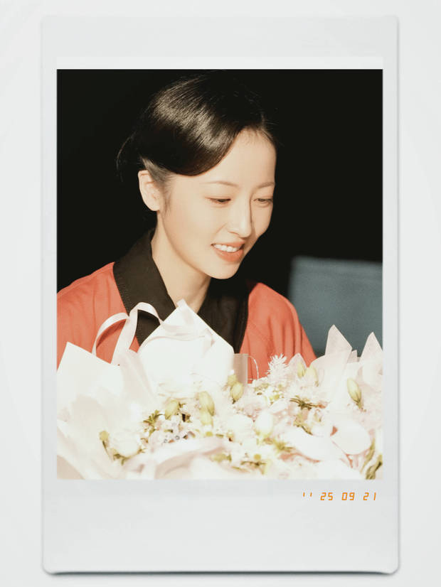 周雨彤梳着斜刘海，笑容可爱。