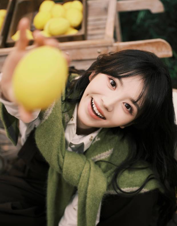 田曦薇手拿柠檬，笑容明媚。