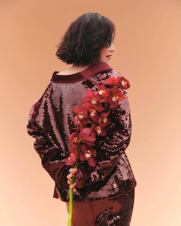 惠英红手持红花，背影窈窕。