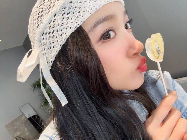 关晓彤对着爱心棒棒糖嘟嘴亲亲，红唇吸睛，好俏皮。