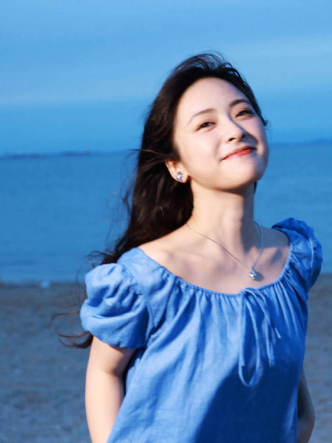 沈月穿蓝色连衣裙海边拍照 笑容甜美氛围感拉满