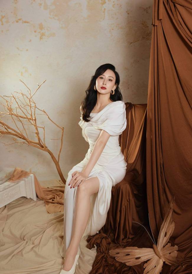 胡静穿白色露肩礼裙姿势优雅 大波浪造型红唇吸睛